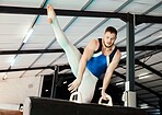Sports, gymnastics and man training on a beam for balance, flexibility and strength in the gym. Fitness, athlete and male gymnast practicing a routine for a competition or performance in an arena.