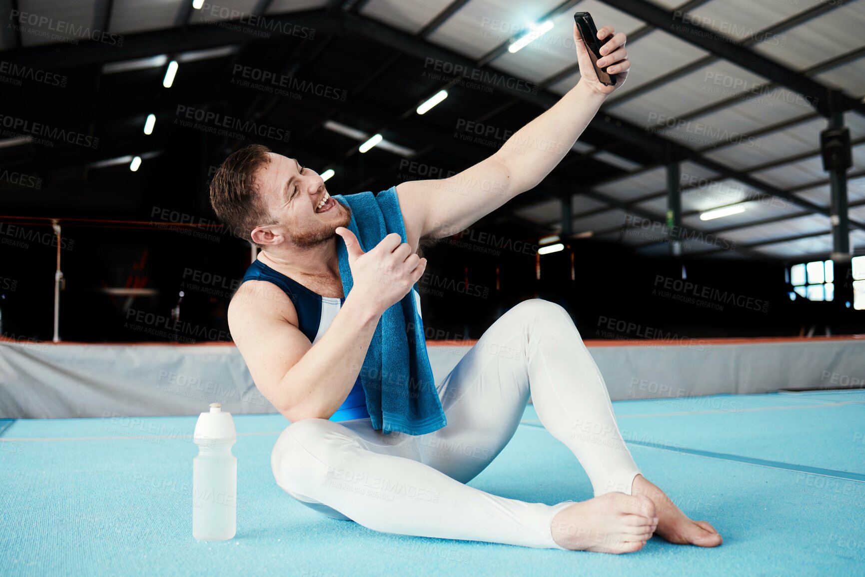 Buy stock photo Man, gymnast and thumbs up for fitness selfie, profile picture or vlog in social media sitting on floor at the gym. Happy male acrobat smile for photo, memory or post showing thumb emoji, like or yes
