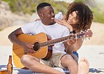 Romance, music and interracial couple with a guitar at the beach, bonding and entertainment. Love, happiness and black man playing a song on an instrument with a woman listening at the ocean