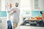 Dance, love and a senior couple in the kitchen of their home together during retirement for bonding. Happy, smile or romance with a mature man and woman pensioner dancing while having fun in a house