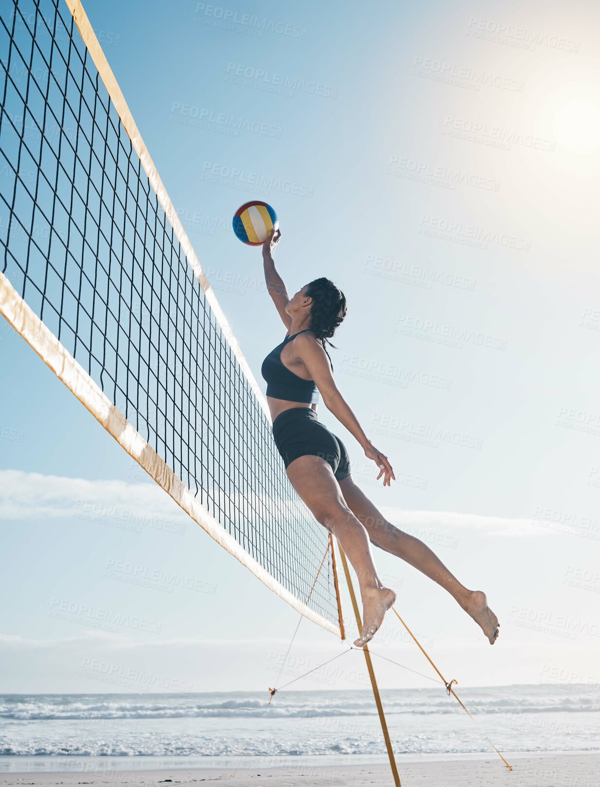 Buy stock photo Woman, jump and volleyball in air on beach by net in serious sports match, game or competition. Fit, active and sporty female person jumping or reaching for ball in volley or spike by the ocean coast