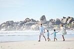 Beach, walking and family holding hands while on a vacation, holiday or adventure. Freedom, love and children with their parents bonding together by the ocean or sea on a tropical summer weekend trip