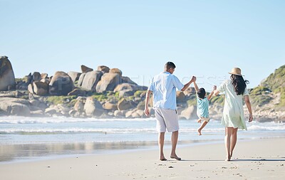 Buy stock photo Family, parents and lifting a child at the beach for fun, adventure and play on holiday. Behind a woman, man and young kid walking on sand or swinging on vacation at the ocean, nature or outdoor