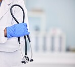 Doctor, hand and stethoscope of professional with arms crossed for medical or healthcare at hospital. Closeup of nurse or surgeon holding tool or equipment in cardiology, health or wellness at clinic