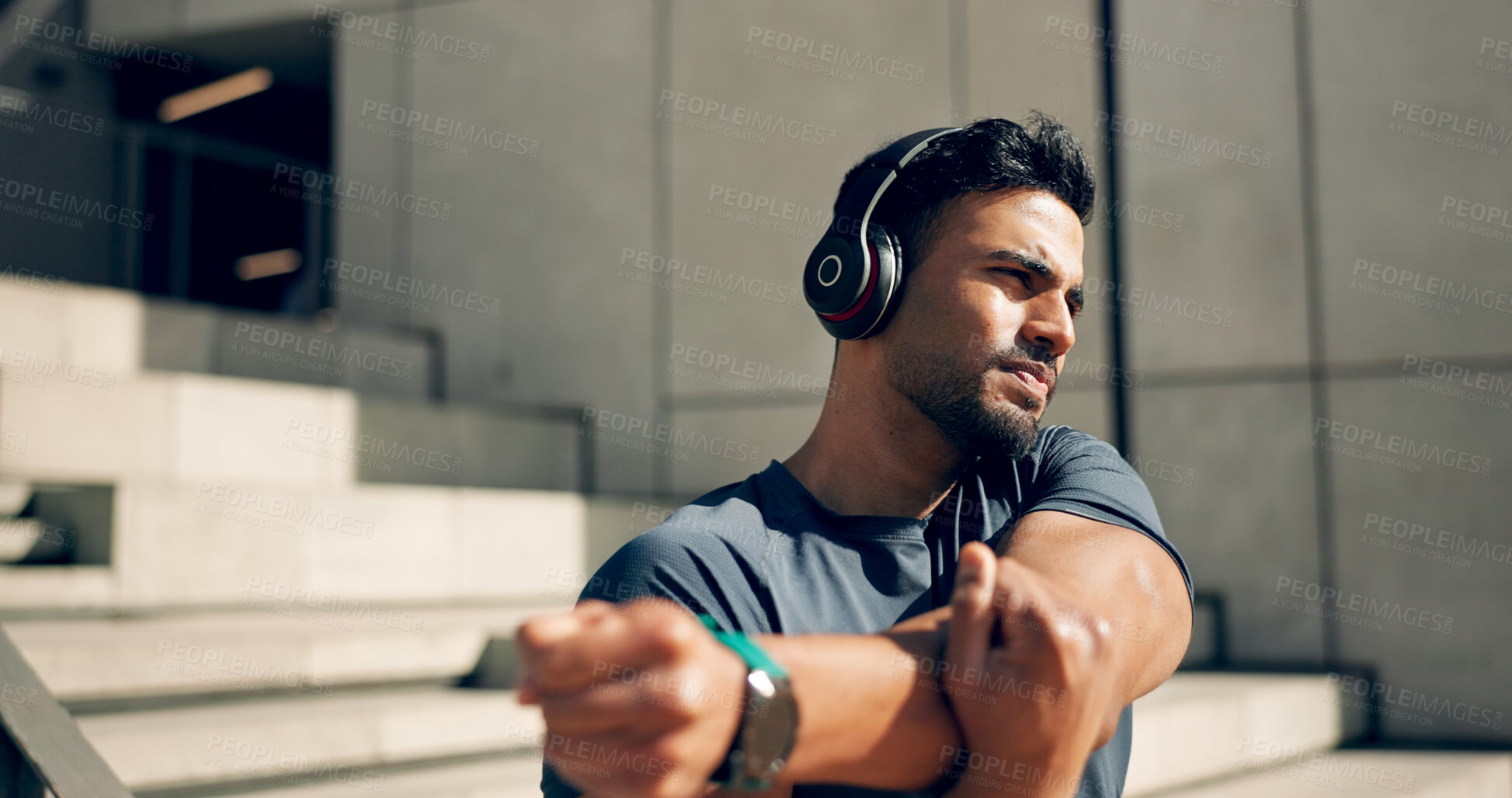 Buy stock photo Fitness, headphones and man stretching arms on stairs in city, workout and exercise for body health. Music, serious athlete and person warm up on steps in urban town, listening to audio and thinking