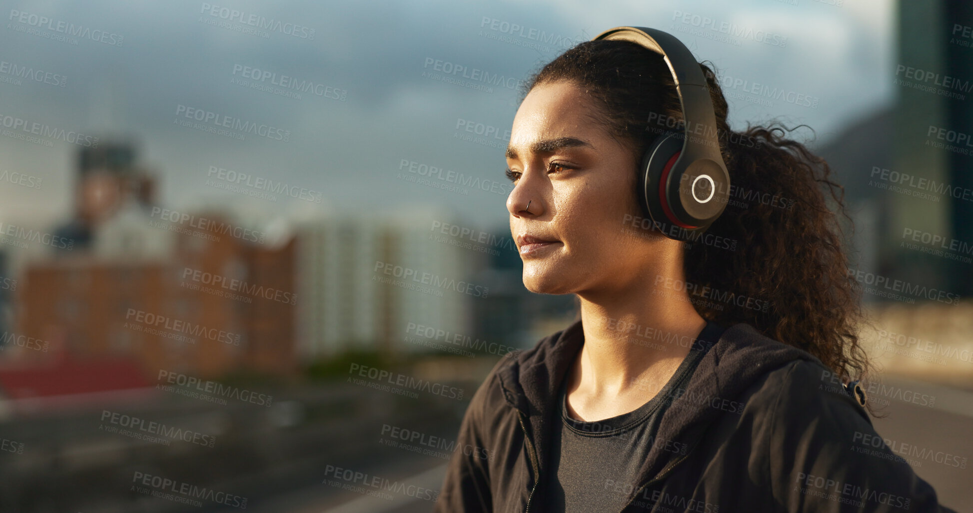 Buy stock photo Woman, runner and headphones in city for fitness in evening sunset, music playlist workout sports. Female person, listen track and training thinking on street for cardio audio, exercise or streaming