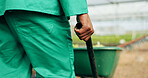 Hand, wheelbarrow and a farmer in a greenhouse for growth, agriculture or sustainability in season. Back, closeup and a equipment on a farm with a person in the countryside for environmental ecology