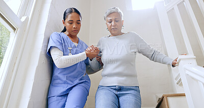 Buy stock photo Woman, nurse and helping senior on stairs in retirement home for support, trust or healthcare. Female person, medical caregiver holding hands with retired or mature patient down a staircase at house