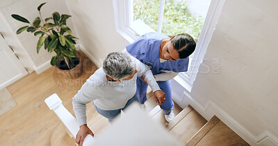 Buy stock photo Woman, nurse and helping senior up stairs in retirement home for support, trust or healthcare. Female person, medical caregiver holding arms on staircase above with retired or mature patient at house