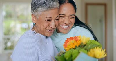 Buy stock photo Hug, love and mother and daughter with flowers in home for bonding, relationship and smile together. Family, happy and mature mom embrace adult woman for mothers day, support and care in living room