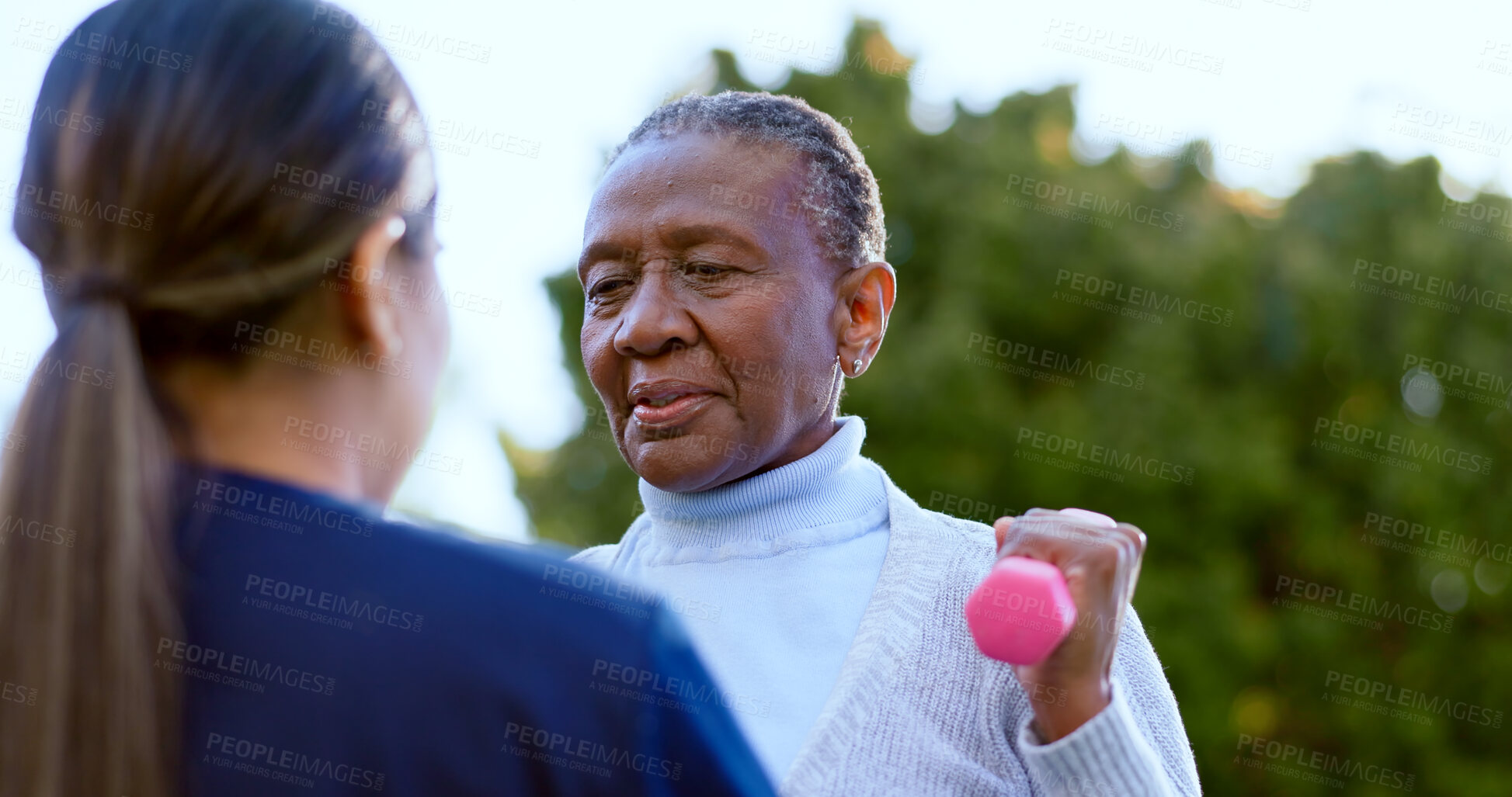 Buy stock photo Dumbbell, fitness and a senior black woman with a nurse outdoor in a garden together for physiotherapy. Exercise, health or wellness with an elderly patient and medical person in the yard to workout