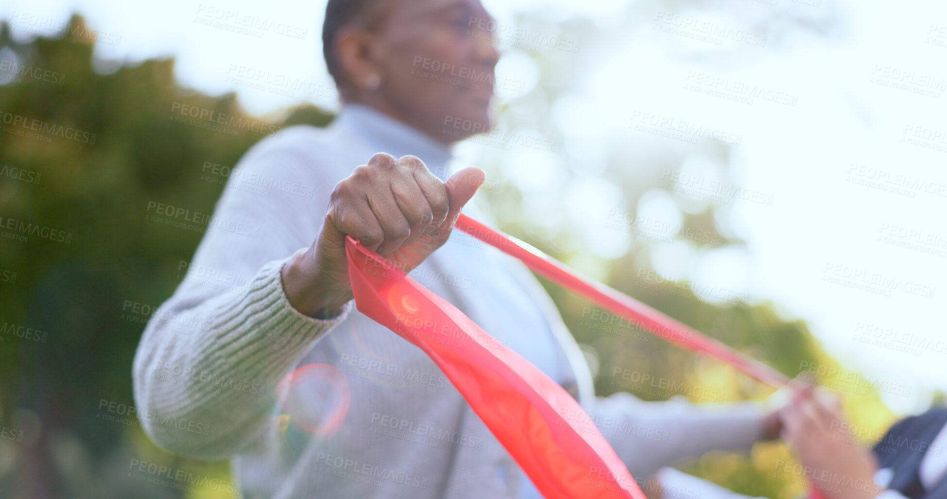 Buy stock photo Woman, hand and resistance band for physiotherapy with exercise in garden, backyard or outdoors. Elderly person, stretching and rehabilitation for mobility with trust, support or help for wellness