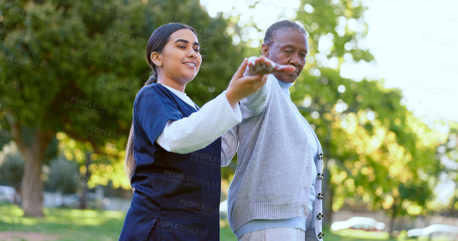 Buy stock photo Elderly, woman and caregiver with arm stretching for exercise, workout or fitness in a park with smile. People, professional or nurse with activity for physiotherapy, wellness and health in nature