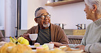 Love, retirement and a senior couple drinking tea in the dining room of their home together in the morning. Smile, relax or conversation with an elderly man and woman in their apartment for romance