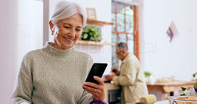 Buy stock photo Senior woman, smile and phone with reading, texting and communication on web, app and typing in home. Elderly lady, drink and happy in kitchen with smartphone, social network and thinking in house