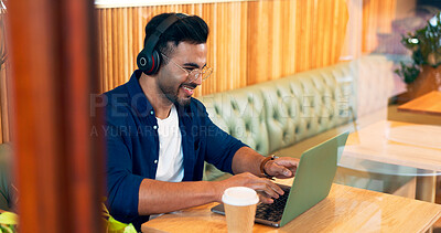 Happy man in cafe, typing on laptop and music for remote work, reading email and writing. Computer, freelancer and editor in coffee shop, headphones and listening to radio, podcast or audio at table