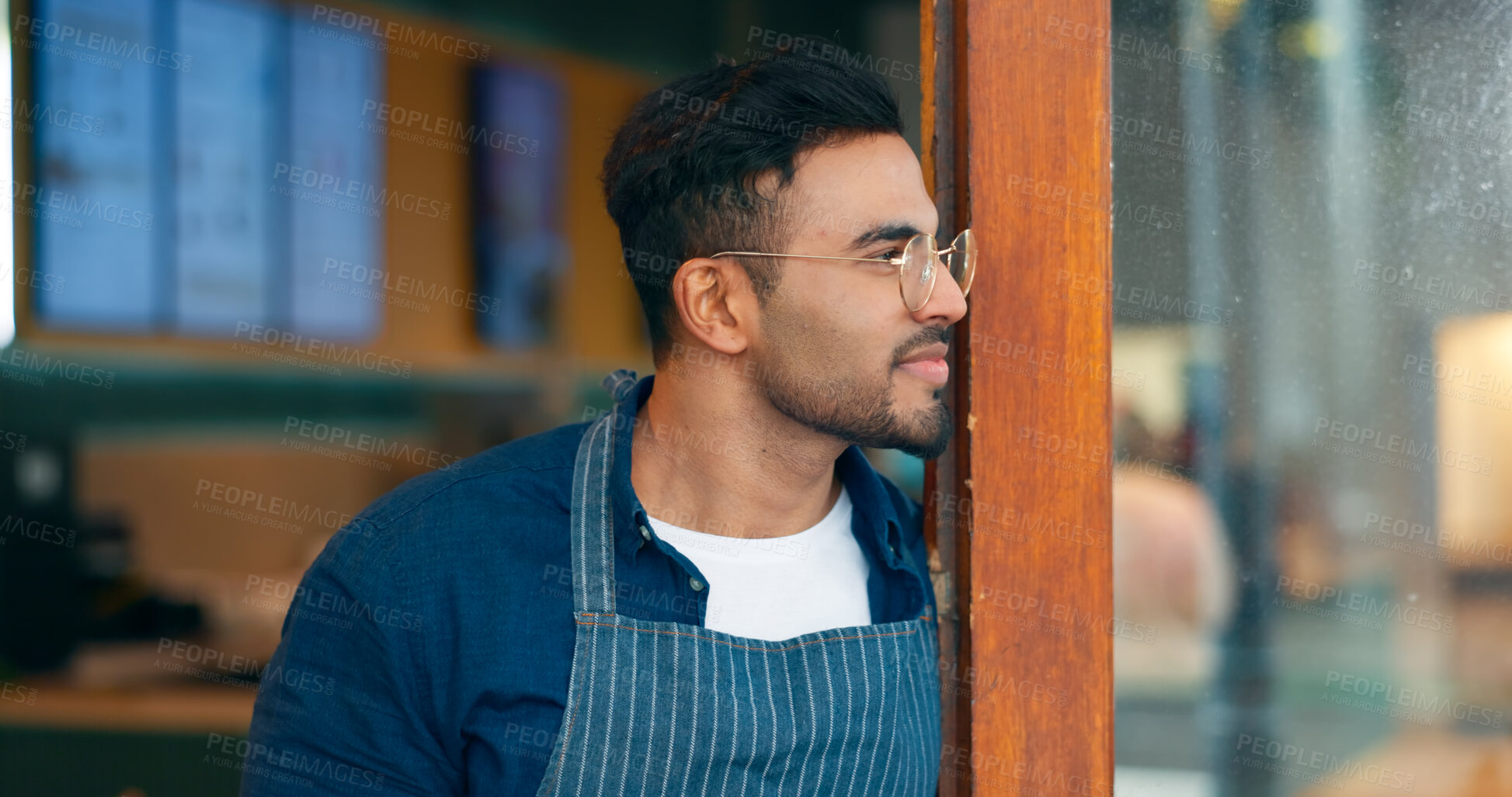 Buy stock photo Small business, coffee shop and a man waiter thinking about hospitality service at the entrance to a restaurant. Face, idea and a young startup entrepreneur working as a barista in a local cafe