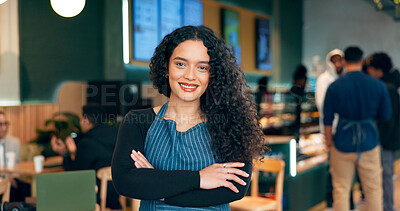 Waitress, woman and portrait with arms crossed or happy for service, welcome or server in coffee shop. Barista, person and face with smile for hospitality, career or confidence in restaurant or cafe