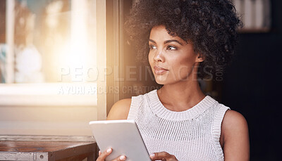 Buy stock photo Shot of a happy young business owner using her tablet while standing inside her coffee shop