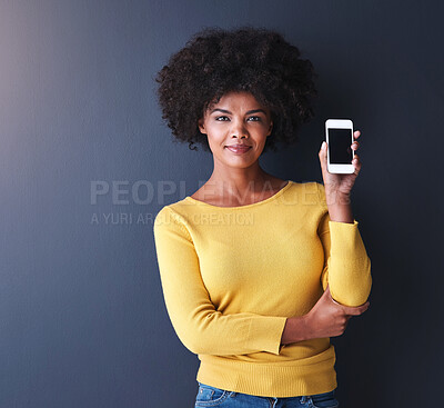 Buy stock photo Studio shot of a young woman holding up her phone against a grey background