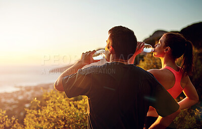 Buy stock photo Cropped shot of a sporty young couple taking a break while out for a run together