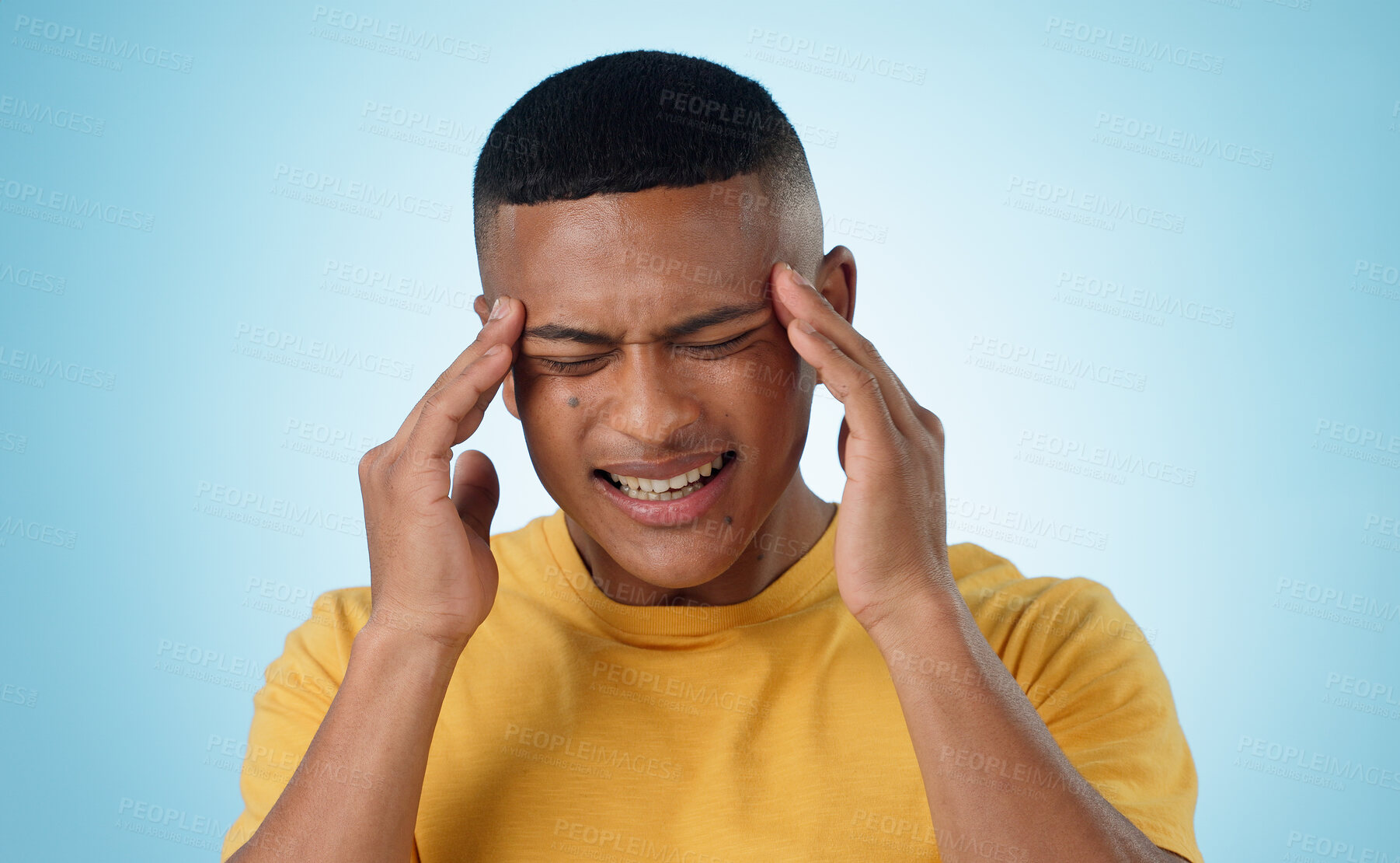 Buy stock photo Headache, stress and man in studio with anxiety, burnout or frustrated by brain fog on blue background. Vertigo, face and male model with temple massage for pain, migraine or fear of tax or audit