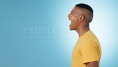 Buy stock photo Angry, man and scream in studio at mockup space for crisis, anger or mad emoji reaction on blue background. Profile of frustrated model shouting with stress, emotional conflict or negative expression