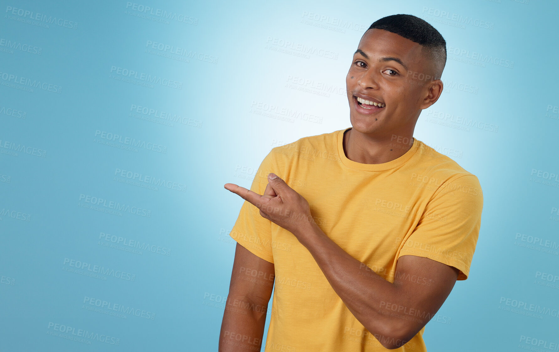 Buy stock photo Man, student pointing and presentation for education, learning or college news and information in studio. Portrait of a young person with university guide, advice and mockup on a blue background