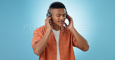Buy stock photo Music, man and dancing with headphones and studio with radio and audio app with blue background. Tech, smile and sound with relax African male person with web media streaming and hearing a song