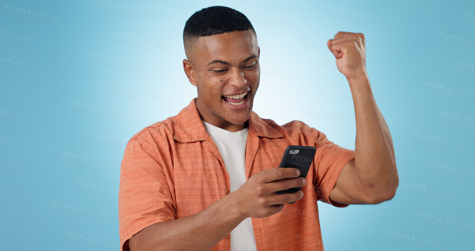 Buy stock photo Man, phone and fist celebration in studio for trading profit, success or revenue by blue background. Investor, trader or person with smartphone for winning, prize or competition with online giveaway