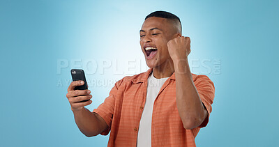Buy stock photo Man, phone and fist with cheers in studio for trading profit, success or revenue by blue background. Investor, trader or person with smartphone for winning, prize or celebration with online giveaway