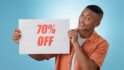Buy stock photo Portrait, happy man and board with sale in studio on blue background for mock up with discount, promo or offer. Cape Town, model or person with poster, notification or announcement for deal in space