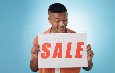 Buy stock photo Happy man, sale and poster for promo in studio for mock up on blue background in Cape Town. Male model, person and excited for announcement, notification or board for information of discount in space