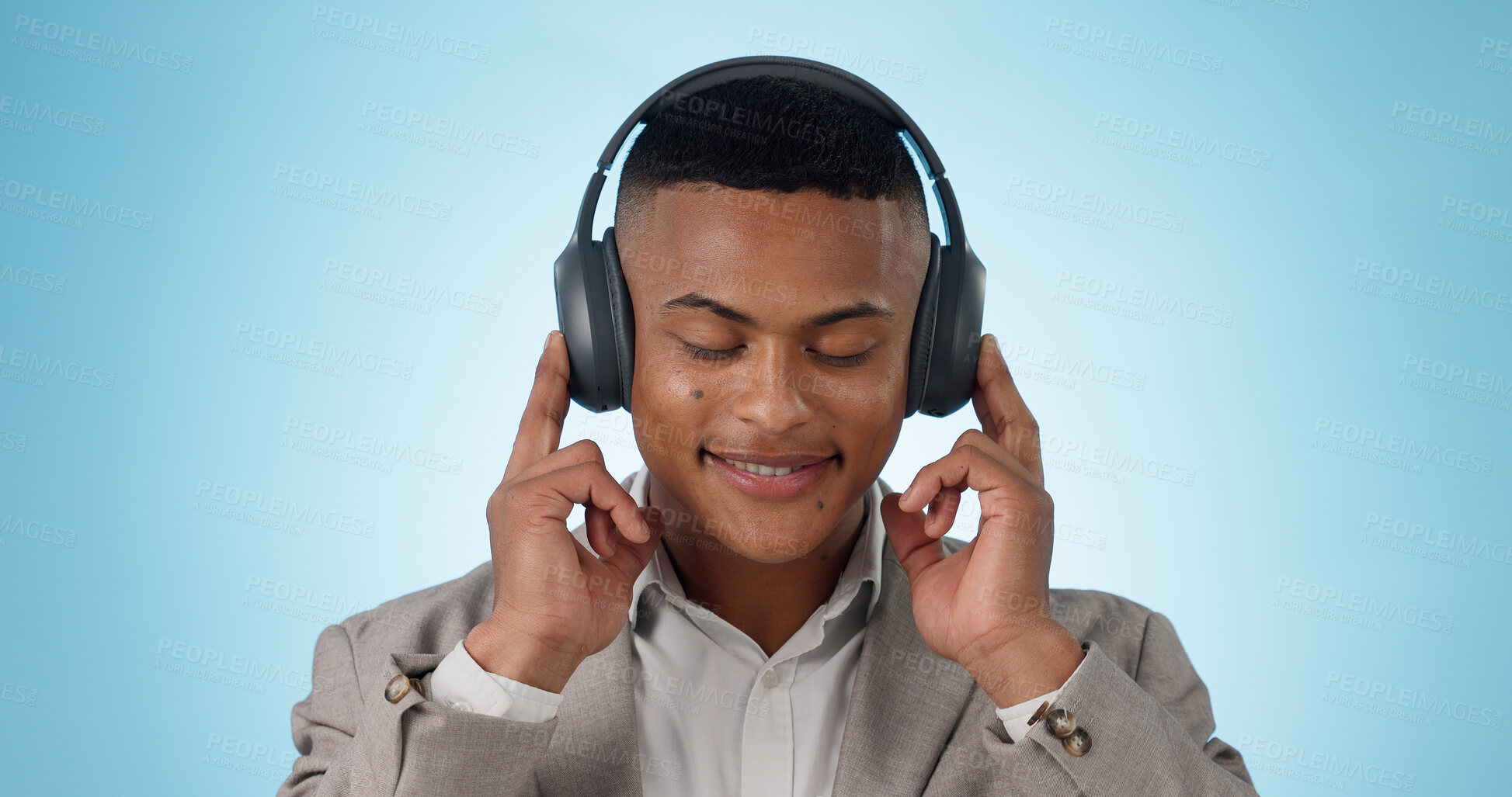 Buy stock photo Music, business man and calm with headphones and studio with radio and audio app with blue background. Tech, smile and sound with relax African male person with web media streaming and hearing a song