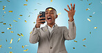 Business man, phone and winning with confetti celebration, stock market news or competition winner in studio. Young trader in wow, surprise and excited for profit or sale on mobile on blue background