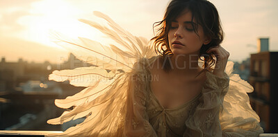 Candid shot of woman with angel wings in sunset. Sitting on building roof . Angle concept.