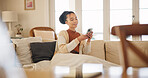 Young woman, phone and relax on sofa, thinking and blanket in home living room for texting, web chat or blog. Girl, excited smile and smartphone with scroll, meme or social media app on lounge couch