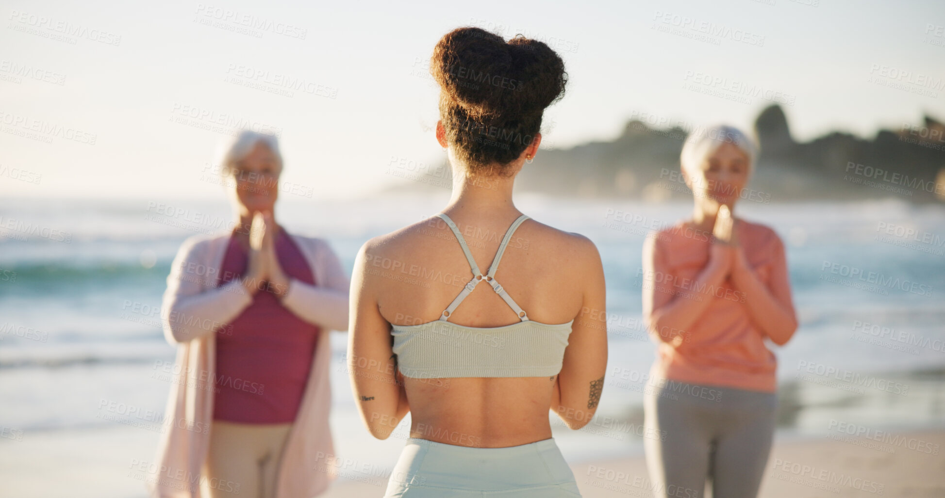 Buy stock photo Beach yoga class, people and back of coach teaching exercise, outdoor wellness and relax workout. Trainer, community instructor and yogi group learning pose, training and teacher coaching pilates