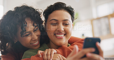 Phone, hug and a gay couple laughing together in their home while browsing a social media app. LGBT, love and comedy with happy lesbian women looking at a meme on a mobile for fun, romance or bonding