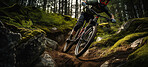 Fit mountain biker speeding downhill on a bike track in the forest or woods. Extreme sport
