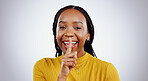 Secret, portrait and black woman with finger on lips in studio for privacy, news or announcement on grey background. Gossip, whisper and face of happy female model with confidential, hand or emoji