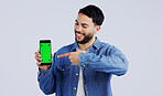 Man, cellphone or pointing to green screen in portrait, mockup space or happy for advertising. Arab person, smile or face in marketing of tracking markers, mobile app or contact by white background