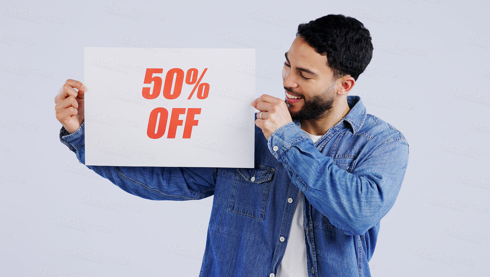 Buy stock photo Happy man, sign and sale in discount, promotion or banner against a gray studio background. Male person or model smile with billboard, poster or half price in advertising or marketing for store promo