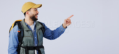 Buy stock photo Happy man, backpack and pointing on mockup for hiking, adventure or travel tips against a studio background. Male person, model or hiker smile with bag showing trekking list, deal or advertising