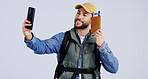 Passport, selfie and happy man in studio for travel, holiday or vacation freedom on grey background. Smartphone, profile picture or traveler with boarding pass, ID or ticket for blog, photo or memory