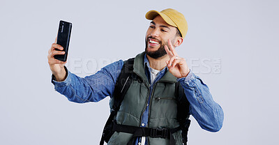 Buy stock photo Hiking, smile and man with selfie, peace sign and social media with fun on white studio background. Person, model and hiker with a smartphone, profile picture and adventure with blog, journey or post