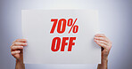 Discount sign, hands with offer and opportunity for shopping, poster and advertising on white background. Store sale, communication and promotion, person with billboard for 70% off deal for service in studio