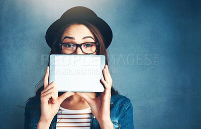 Buy stock photo Portrait, tablet and mockup with a fashion woman in studio on a blue background for social media marketing. Face, display and style with a young person holding an empty screen for advertising space