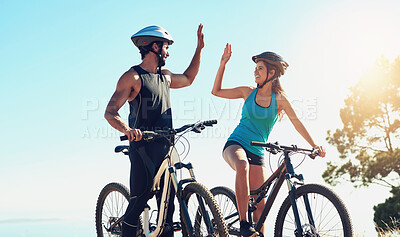 Buy stock photo Shot of a happy young couple out mountain biking together