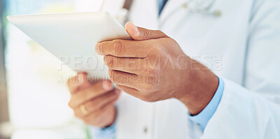 Buy stock photo Shot of an unidentifiable doctor checking a patient's medical records on his tablet